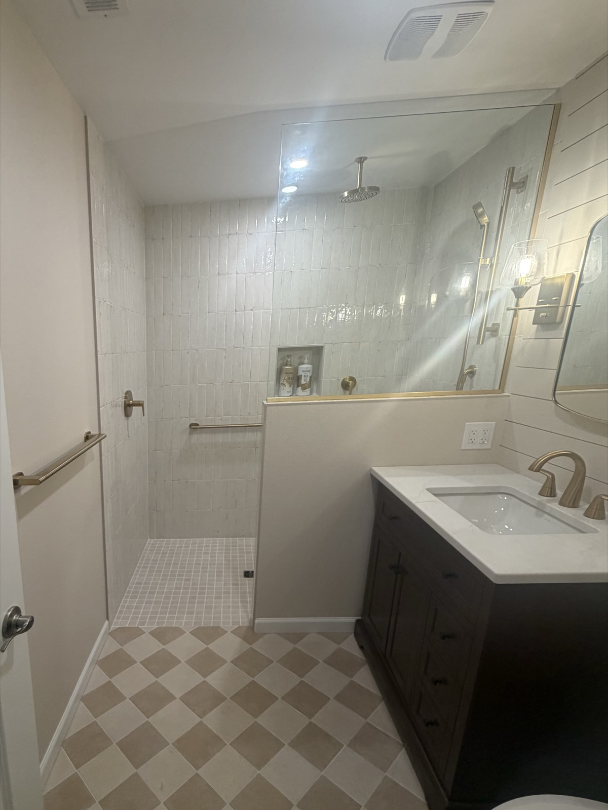 Bathroom remodel with brass fixtures, glass walk-in shower, and dark vanity