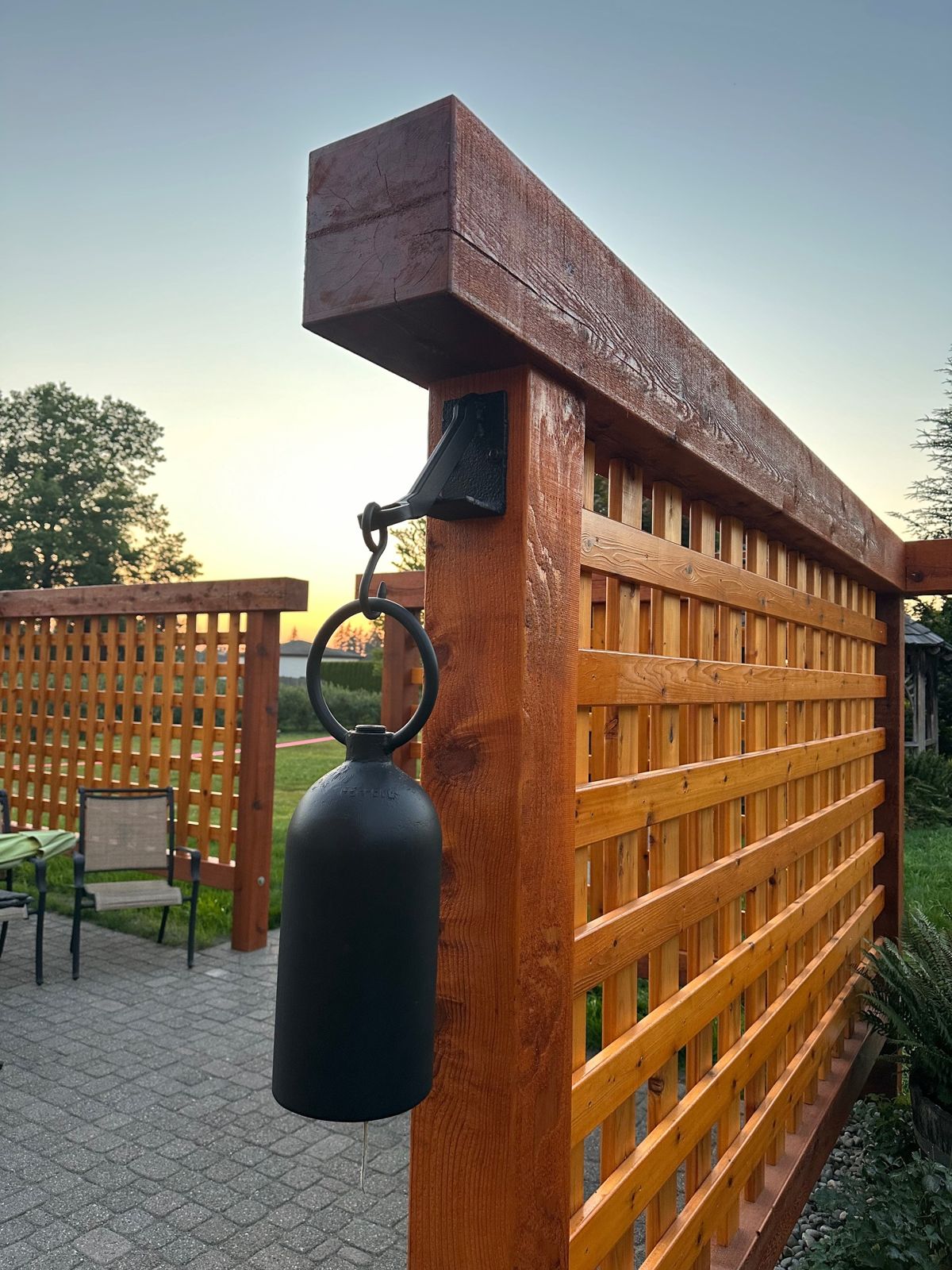 Cedar screen with hanging bell at sunset