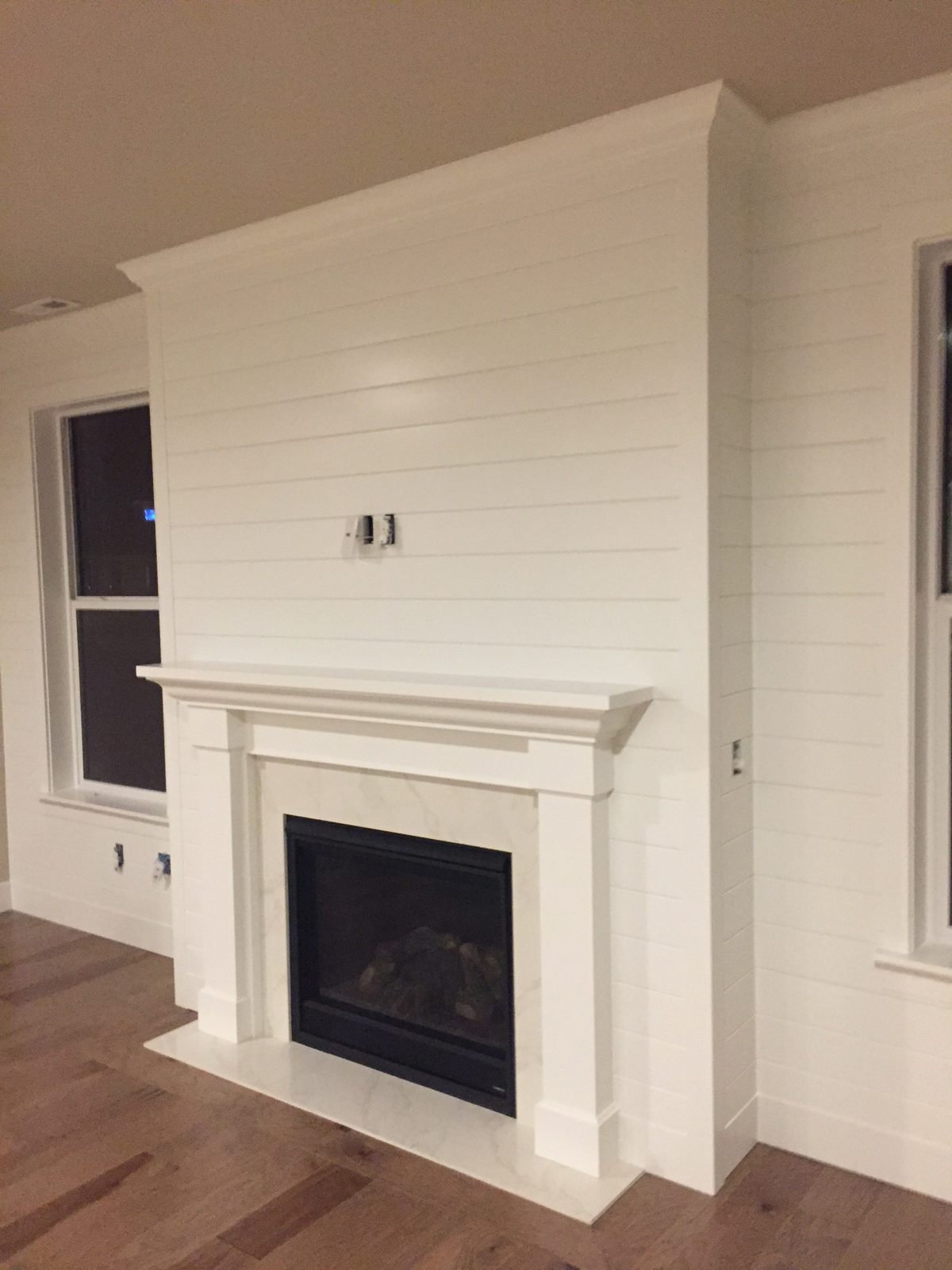 Shiplap fireplace wall with craftsman mantel and marble surround