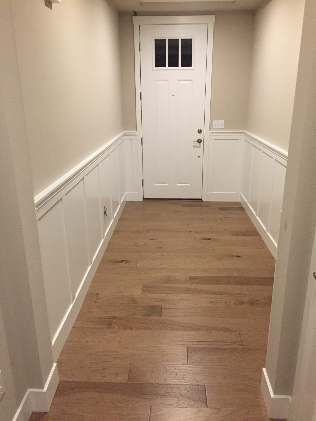 Entry hall board-and-batten wainscoting with hickory hardwood floors