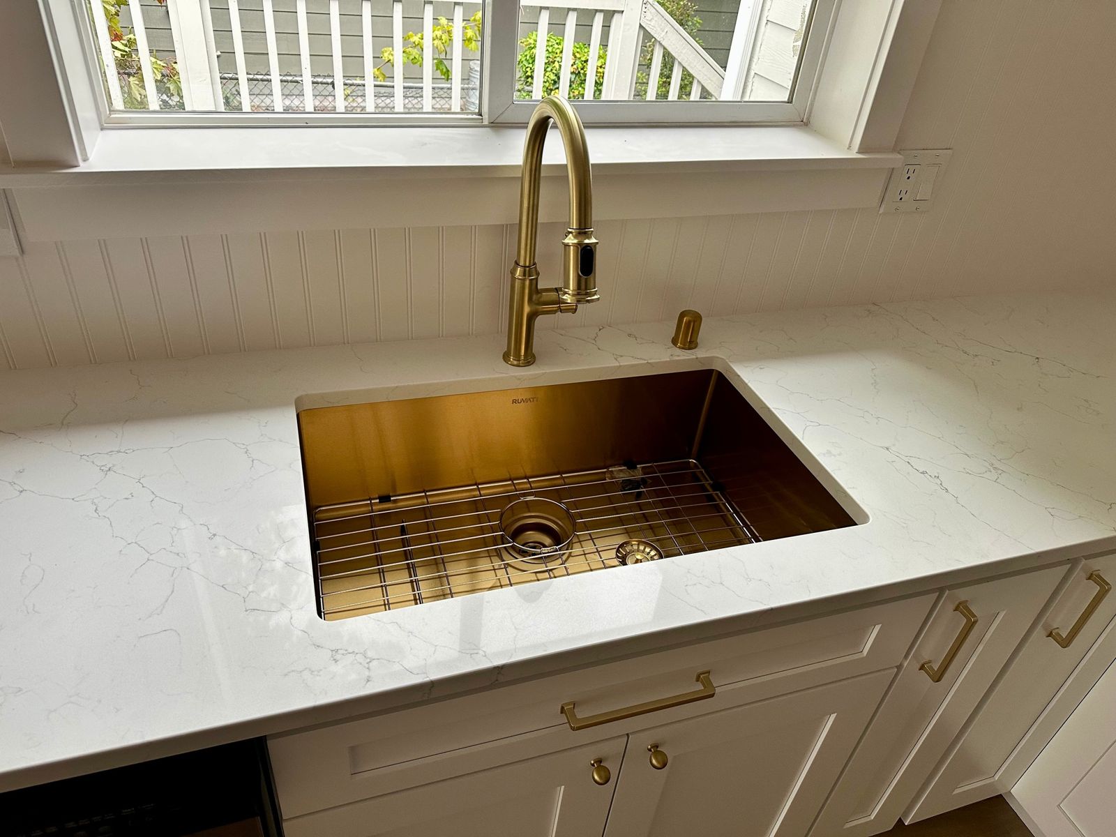 Brushed-gold undermount sink on white quartz
